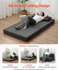 A woman is lying on a dark gray folding sofa bed, which is shown in multiple configurations. Podgląd zdjęcia produktu