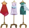Three doll-sized dresses on mannequins. Produktbild-Vorschau