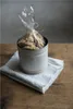 A white tin of cookies sits on a linen napkin on a wooden table. Produktbild-Vorschau
