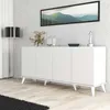 A white console table with four doors, decorated with a sculpture and a vase, placed against a textured gray wall. Produktbild-Vorschau