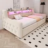 A beige upholstered daybed with a tufted headboard and integrated shelving with LED lighting. Produktbild-Vorschau