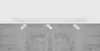 A white track light fixture with three black spotlights is mounted on a white ceiling above a textured gray concrete wall. Náhľad obrázku produktu