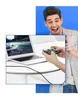 A man is excitedly looking at a laptop and a smartphone connected by a cable. Podgląd zdjęcia produktu