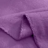 A close-up view of a folded purple fleece blanket, showing the texture and stitching of the hem. Produktbild-Vorschau