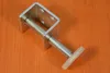 A single furniture foot is placed on an orange wooden surface. Produktbild-Vorschau