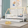 A white wooden house-shaped bed with a pull-out trundle bed, decorated with string lights, in a child's room. Produktbild-Vorschau