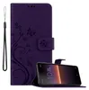A purple flip case for a Sony Xperia 10 II phone, with a floral design and a black wrist strap, is shown next to the phone it is designed for. Náhled obrázku produktu