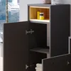 A close-up view of an open cabinet with shelves and items inside, set against a window with a view of buildings. Náhled obrázku produktu