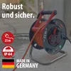 A heavy-duty extension cord reel with orange cable, designed for outdoor use, is shown in a close-up shot. Produktbild-Vorschau