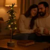 A couple is sitting on a couch, with a small decorated Christmas tree and a book on a coffee table in the foreground. Produktbild-Vorschau