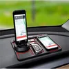 Schwarze rutschfeste Auto-Armaturenbrett-Matte mit roten Akzenten, die zwei Smartphones mit Navigation und einen Autoschlüssel hält Náhľad obrázku produktu