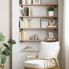 A wooden chair sits in front of a bookshelf filled with books and decorative items. Náhľad obrázku produktu