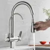 A hand is shown operating a kitchen faucet, with water flowing from both spouts. Náhľad obrázku produktu