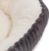 A close-up view of the edge of a soft pet bed, showing the textured gray outer material and the plush cream inner lining. Produktbild-Vorschau