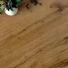 A close-up view of a wooden surface with a white vase containing some greenery in the upper left corner. Produktbild-Vorschau