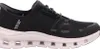 A side view of a black Skechers shoe with a pink sole. Voir les images du produit