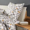 A close-up view of a bed with patterned bedding and pillows. Produktbild-Vorschau