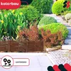A beautifully landscaped garden with various plants and a decorative wooden fence. Voir les images du produit
