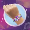 A close-up of a person's wrist wearing a colorful bracelet with musical notes and a crown charm. Náhľad obrázku produktu
