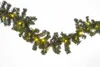 A garland of artificial pine branches with small yellow lights, displayed against a white background. Produktbild-Vorschau