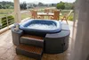 An inflatable hot tub on a patio with a view of a field and trees. Náhľad obrázku produktu