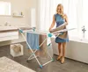 A woman is hanging towels on a drying rack in a modern bathroom. Náhled obrázku produktu