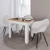 A dining table set with four chairs in a modern dining room. Produktbild-Vorschau