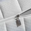 A close-up view of a mattress zipper and quilted fabric. Produktbild-Vorschau