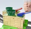A close-up of a Hot Wheels Mario Kart race track accessory, showing two green pipes and two levers being operated by a hand. Produktbild-Vorschau
