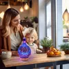 A woman and a child are sitting at a table with an aroma diffuser. Voir les images du produit
