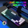 A gaming keyboard with RGB lighting is displayed on a dark, reflective surface, with game controllers in the background. Produktbild-Vorschau