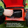 A hand is shown inserting a mulch kit into a lawnmower. Produktbild-Vorschau