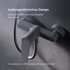 A close-up of a modern gray shower faucet mounted on a textured gray wall, with text overlays describing its design and origin. Produktbild-Vorschau