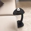 A black marble-look side table with a C-shaped base is placed next to a beige sofa on a light beige rug. A white cup and a smartphone are on the table. Podgląd zdjęcia produktu