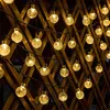 String lights with spherical bulbs are attached to a wooden lattice fence. Voir les images du produit