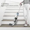 A person is holding a cordless wet and dry vacuum cleaner on a staircase. Produktbild-Vorschau