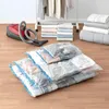 Vacuum bags and a vacuum cleaner are shown on a wooden floor, with folded clothes and bedding in the background. Voir les images du produit