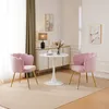 Two pink velvet chairs are placed around a small white table in a room with a white cabinet and artwork on the wall. Náhľad obrázku produktu