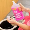 A person is holding a bottle of pink floor cleaner over a mop bucket. Voir les images du produit