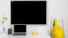 A desk setup with a laptop, a whiteboard, a lamp, a camera, a lemon, a glass of water, and a backpack on a ladder. Produktbild-Vorschau