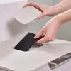 A person's hands are shown inserting a charcoal filter into a compost bin. Podgląd zdjęcia produktu