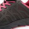 A close-up view of the side of a black and pink athletic shoe. Voir les images du produit