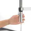 A hand is shown pressing a button on a kitchen faucet, with water flowing out. Anteprima dell’immagine prodotto