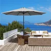 A patio set with a large umbrella on a wooden deck overlooking the ocean. Produktbild-Vorschau