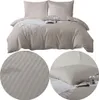 A collage of images showing a taupe striped duvet cover and pillowcases, with close-up views of the fabric texture and a styled bed. Podgląd zdjęcia produktu