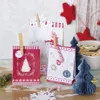 Christmas-themed advent calendar bags with decorations and cookies. Produktbild-Vorschau