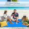 A couple relaxing on a beach blanket on a sandy beach with the ocean in the background. Produktbild-Vorschau