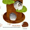 A cat is sitting on a cat tree that looks like a tree trunk with green leaf-shaped platforms. The base of the cat tree is shown with text and a close-up of the base material. Produktbild-Vorschau