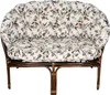 A studio shot of a two-seater rattan sofa with a floral patterned cushion. Náhled obrázku produktu