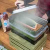 A person is smoking salmon in a smoker on a wooden deck. Produktbild-Vorschau